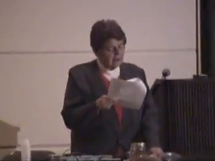 Hulda Clark reading from a case file at the podium