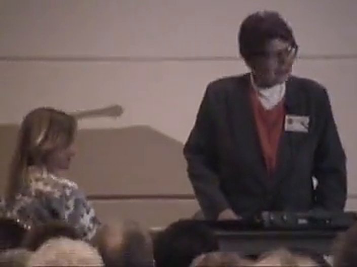 Hulda Clark demonstrating the Syncrometer at the podium